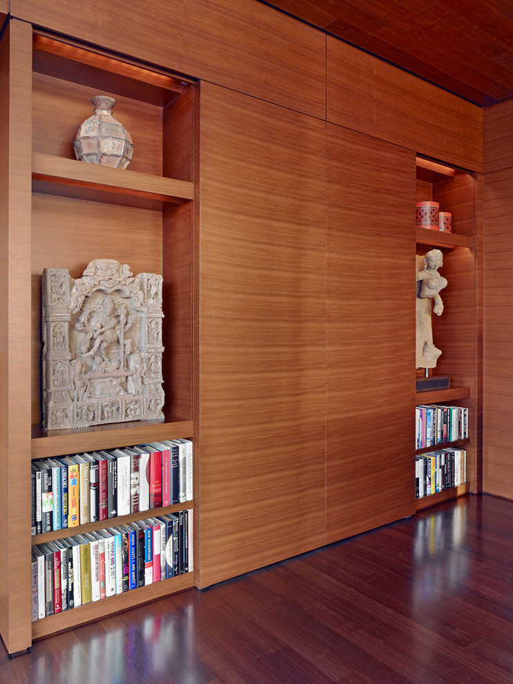 Ejemplo de sala de estar con biblioteca asiática con suelo de madera oscura