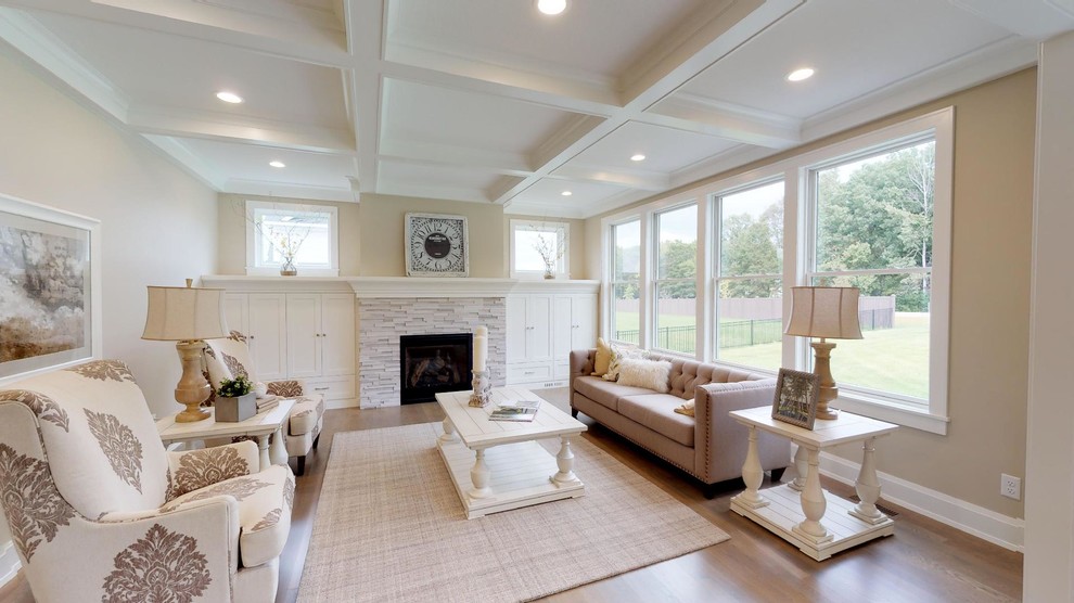 Imagen de sala de estar abierta de estilo de casa de campo grande con paredes grises, suelo de madera clara, todas las chimeneas, marco de chimenea de piedra y suelo gris