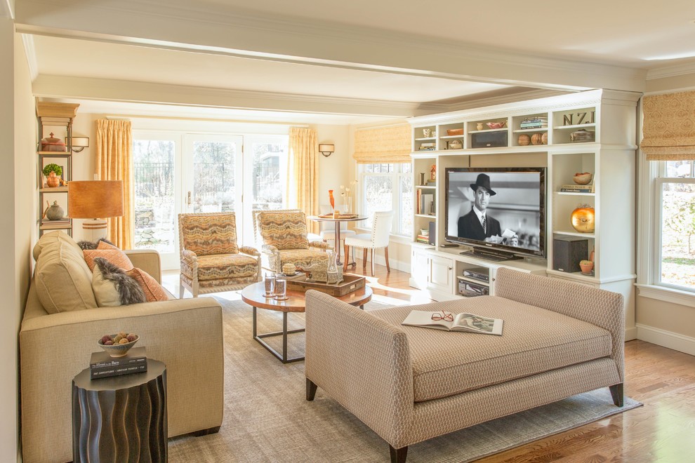 Immagine di un grande soggiorno classico aperto con pareti beige, pavimento in legno massello medio e parete attrezzata