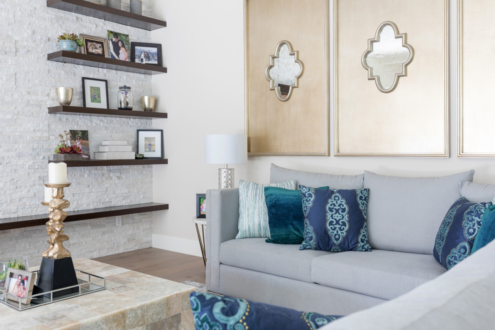 Ejemplo de sala de estar abierta tradicional renovada de tamaño medio con paredes grises, suelo de madera clara, televisor colgado en la pared y suelo marrón