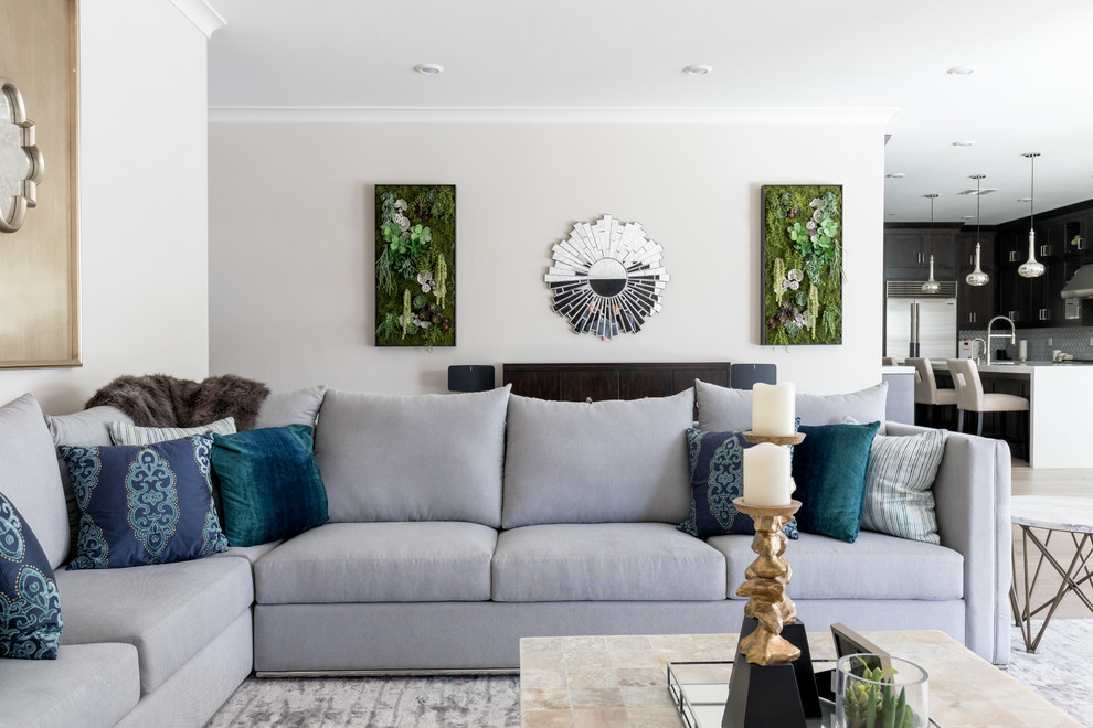 Modelo de sala de estar abierta clásica renovada de tamaño medio con paredes grises, suelo de madera clara, televisor colgado en la pared y suelo marrón