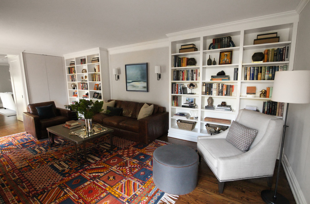 Esempio di un soggiorno chic di medie dimensioni e chiuso con libreria, pareti marroni, pavimento in legno massello medio, nessun camino e TV a parete