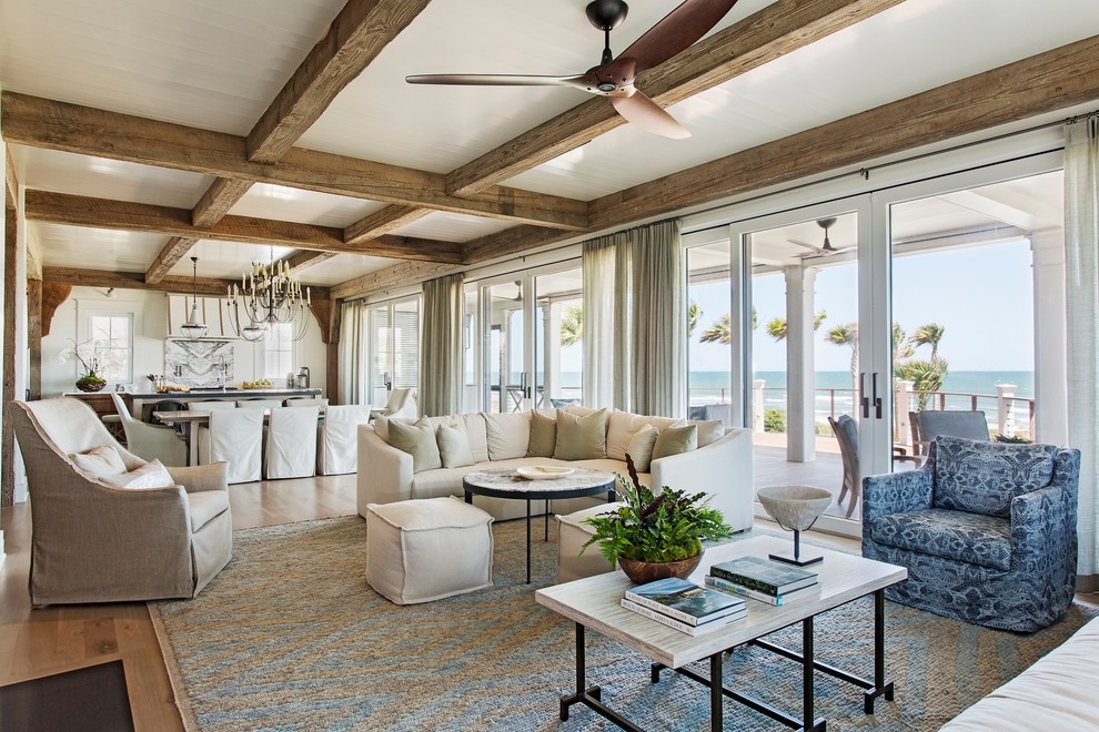 Idee per un ampio soggiorno stile marinaro aperto con pareti bianche, parquet chiaro, pavimento marrone e tappeto