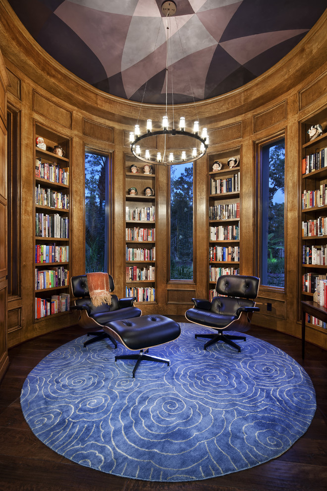 Пример оригинального дизайна: гостиная комната в современном стиле с с книжными шкафами и полками, темным паркетным полом и ковром на полу