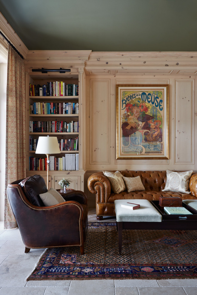На фото: изолированная гостиная комната среднего размера в средиземноморском стиле с с книжными шкафами и полками, полом из известняка, бежевым полом, бежевыми стенами и ковром на полу