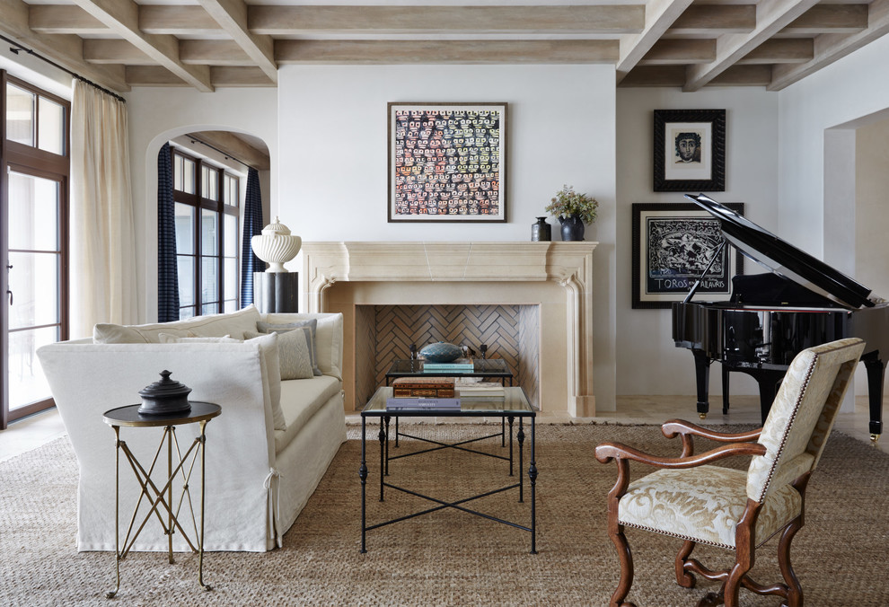 Exemple d'un grand salon méditerranéen fermé avec une salle de musique, un mur blanc, une cheminée standard, aucun téléviseur, un sol en calcaire, un manteau de cheminée en pierre et un sol beige.