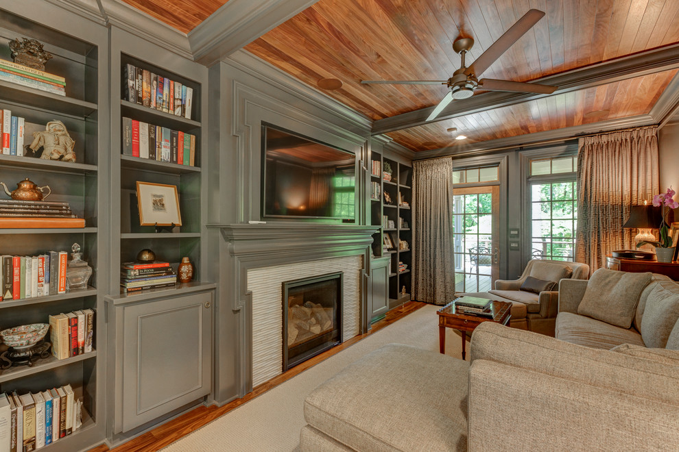 Inspiration for a large traditional open plan games room in Raleigh with grey walls, dark hardwood flooring, a standard fireplace, a tiled fireplace surround and a wall mounted tv.