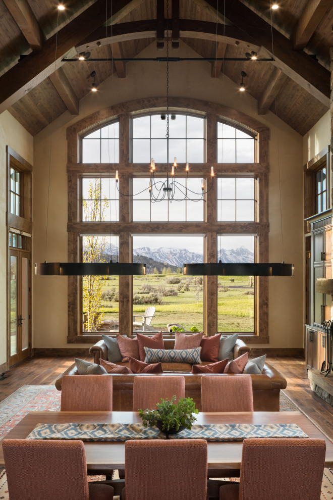 Diseño de sala de estar rústica con suelo de madera en tonos medios y vigas vistas
