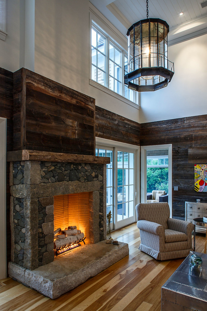 Foto de sala de estar abierta tradicional renovada grande sin televisor con paredes marrones, todas las chimeneas y marco de chimenea de piedra