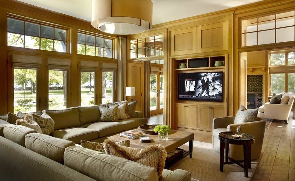 Inspiration for an eclectic medium tone wood floor family room remodel in Chicago with beige walls and a media wall
