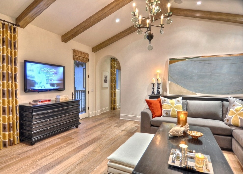 Example of a large trendy enclosed medium tone wood floor family room design in Orange County with white walls and no fireplace