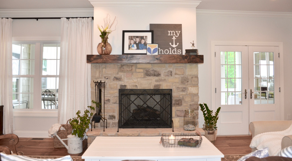Пример оригинального дизайна: открытая гостиная комната среднего размера в классическом стиле с серыми стенами, светлым паркетным полом, стандартным камином, фасадом камина из камня, телевизором в углу и бежевым полом