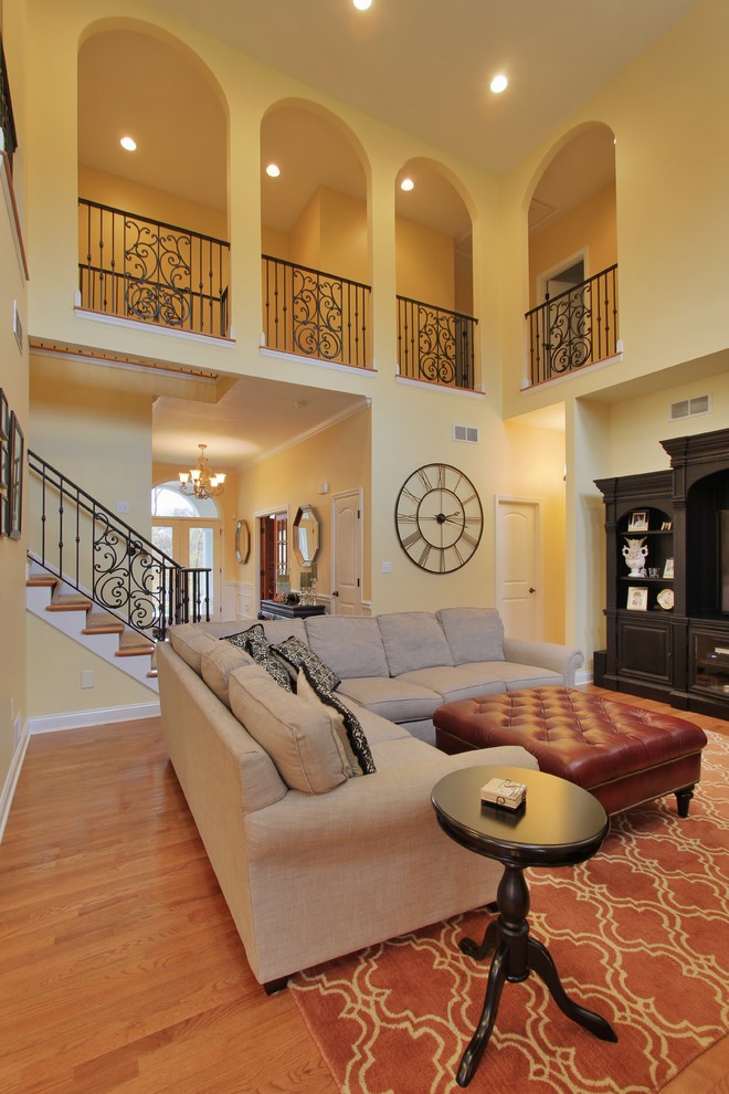 Imagen de sala de estar mediterránea con suelo de madera en tonos medios, todas las chimeneas y marco de chimenea de baldosas y/o azulejos