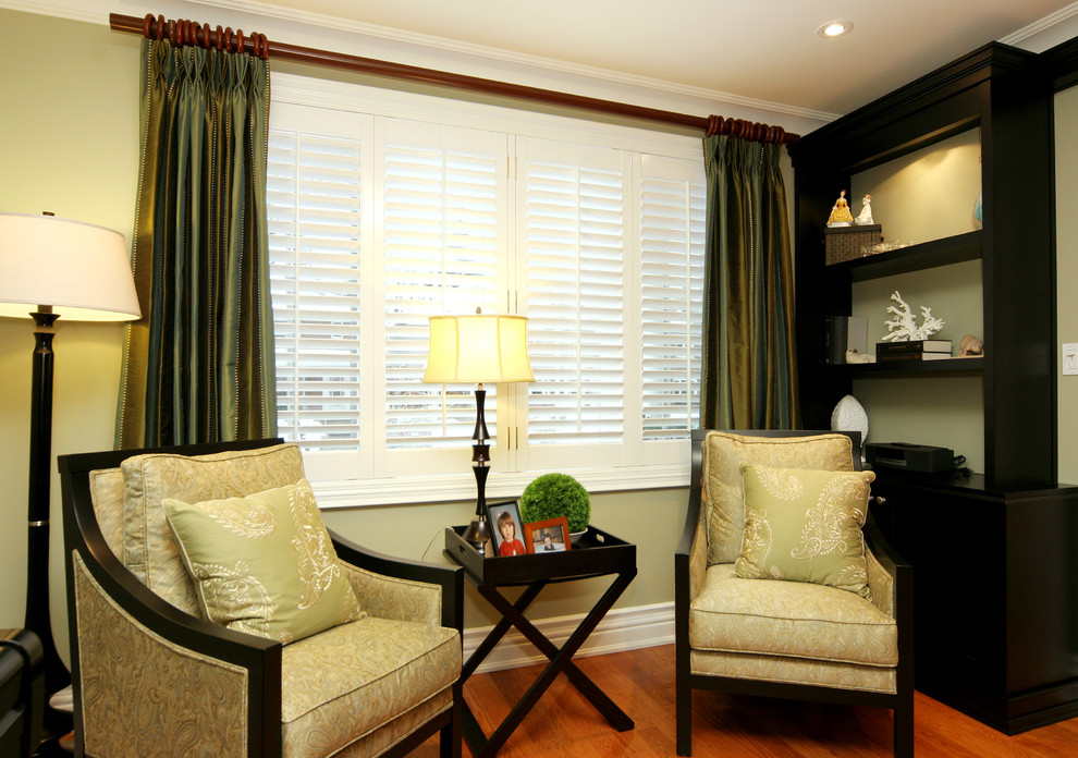 Diseño de sala de estar cerrada tradicional de tamaño medio con paredes verdes y suelo de madera clara