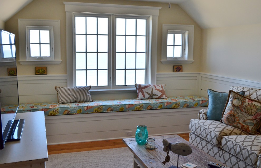 Cette photo montre une salle de séjour mansardée ou avec mezzanine bord de mer avec un mur beige, parquet clair et un téléviseur indépendant.