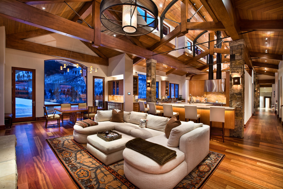 This is an example of a traditional open plan games room in Denver with beige walls and medium hardwood flooring.