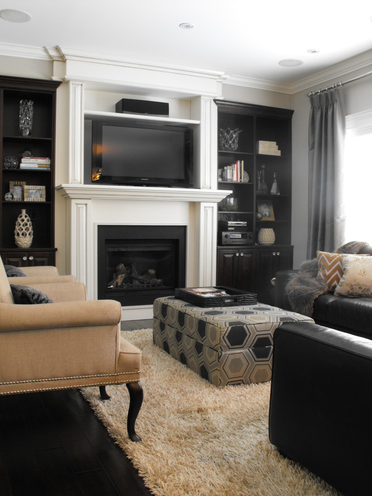 Идея дизайна: открытая гостиная комната в стиле неоклассика (современная классика) с серыми стенами, темным паркетным полом, стандартным камином, фасадом камина из штукатурки и телевизором на стене