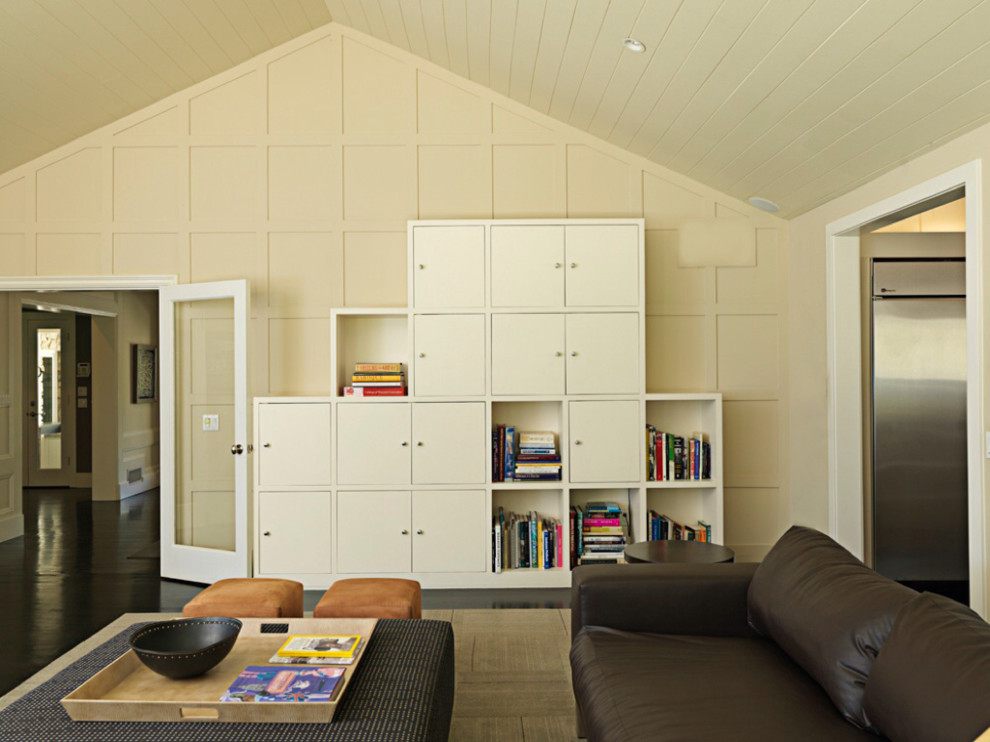Réalisation d'une salle de séjour design avec un mur beige et canapé noir.