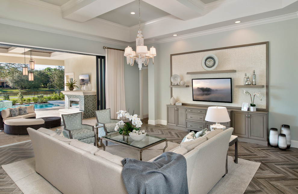 Modelo de sala de estar abierta clásica renovada extra grande con suelo de baldosas de cerámica, televisor colgado en la pared y paredes azules