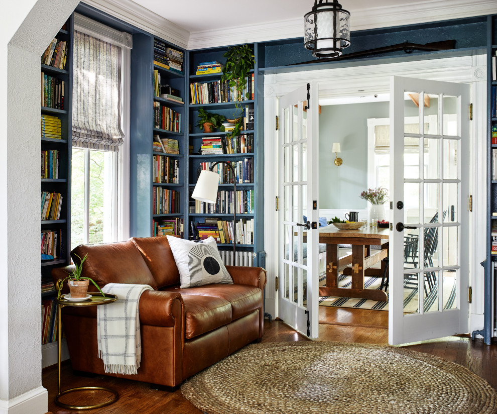 Источник вдохновения для домашнего уюта: изолированная гостиная комната в стиле кантри с синими стенами, паркетным полом среднего тона, коричневым полом и с книжными шкафами и полками