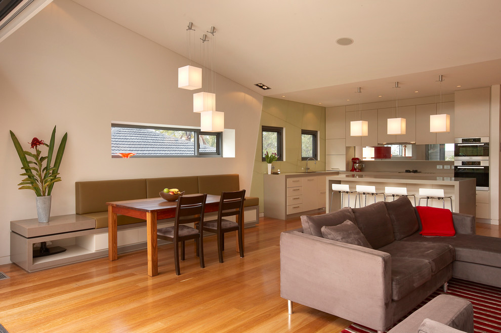 Modelo de sala de estar con biblioteca cerrada y abovedada contemporánea de tamaño medio con pared multimedia, paredes blancas, suelo de madera en tonos medios y suelo rojo