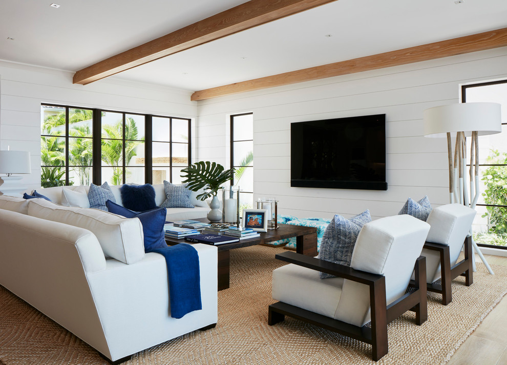 Modelo de sala de estar marinera con paredes blancas, televisor colgado en la pared y alfombra