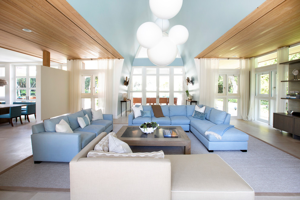 Foto di un grande soggiorno design aperto con pareti blu, nessun camino, pavimento beige, TV nascosta e pavimento in laminato