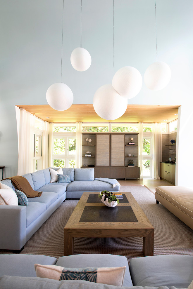 Großes, Offenes Modernes Wohnzimmer ohne Kamin mit blauer Wandfarbe, Laminat, verstecktem TV und braunem Boden in Miami