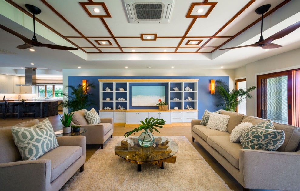 Пример оригинального дизайна: большая открытая гостиная комната в морском стиле с синими стенами, светлым паркетным полом, телевизором на стене и бежевым полом