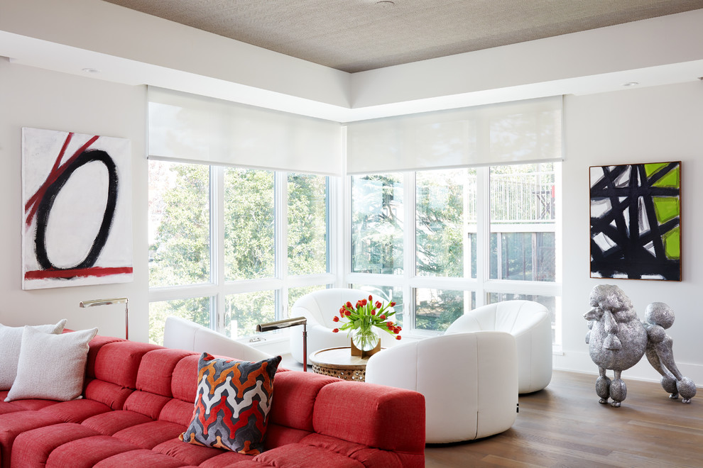 Ejemplo de sala de estar abierta contemporánea de tamaño medio sin chimenea con paredes blancas, suelo de madera clara, televisor colgado en la pared y suelo marrón