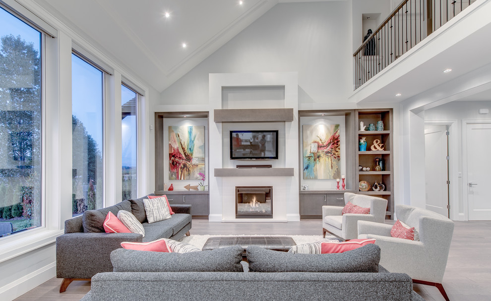 Design ideas for a large traditional open plan living room in Vancouver with white walls, medium hardwood flooring, a standard fireplace, a wall mounted tv and grey floors.