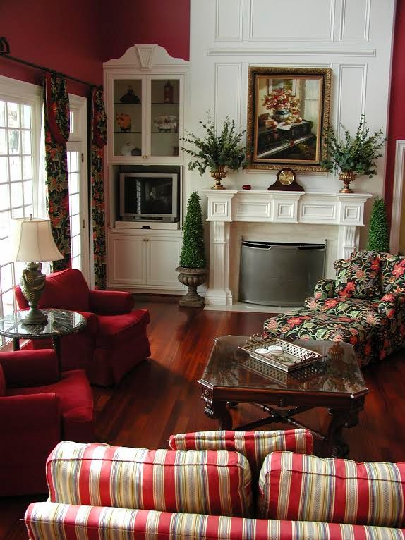 Пример оригинального дизайна: гостиная комната среднего размера в классическом стиле с с книжными шкафами и полками, красными стенами, темным паркетным полом и мультимедийным центром