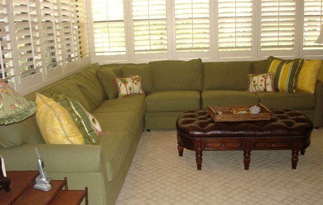 Diseño de sala de estar cerrada tropical de tamaño medio con paredes amarillas, moqueta y televisor retractable