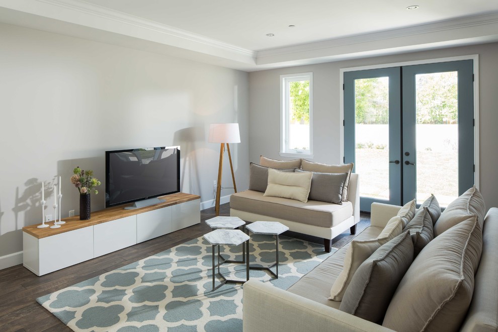 Modelo de sala de estar actual de tamaño medio con paredes grises, suelo de madera oscura y televisor independiente
