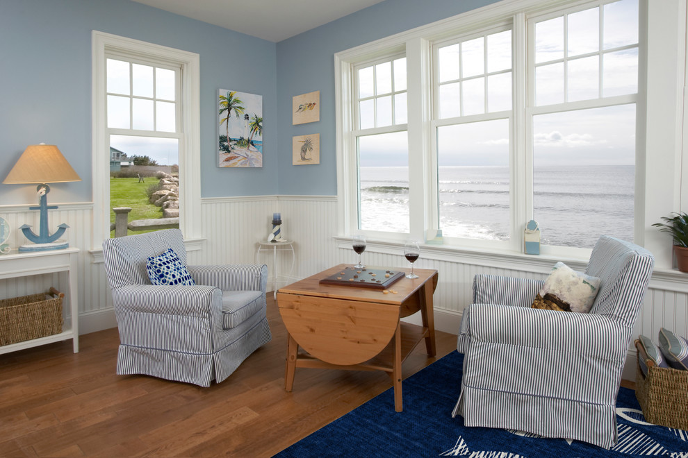 Esempio di un soggiorno stile marino di medie dimensioni e chiuso con libreria, pareti blu, pavimento in legno massello medio e pavimento marrone