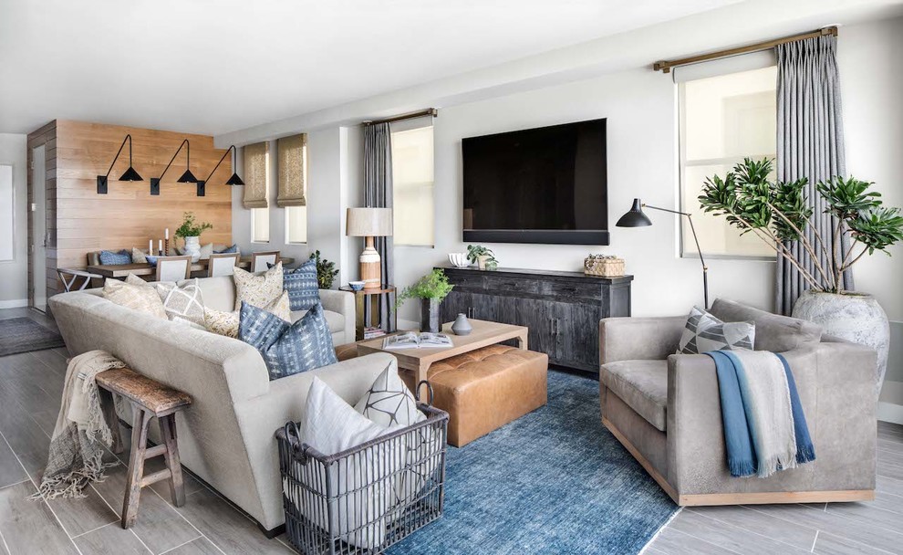 Diseño de sala de estar abierta costera de tamaño medio sin chimenea con paredes blancas, televisor colgado en la pared, suelo gris y suelo de madera clara