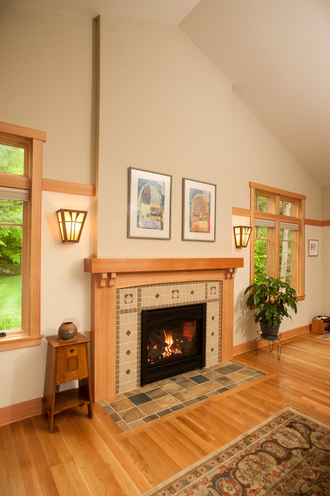Réalisation d'une salle de séjour craftsman de taille moyenne et ouverte avec un mur beige, parquet clair, une cheminée standard, un manteau de cheminée en carrelage et un téléviseur indépendant.