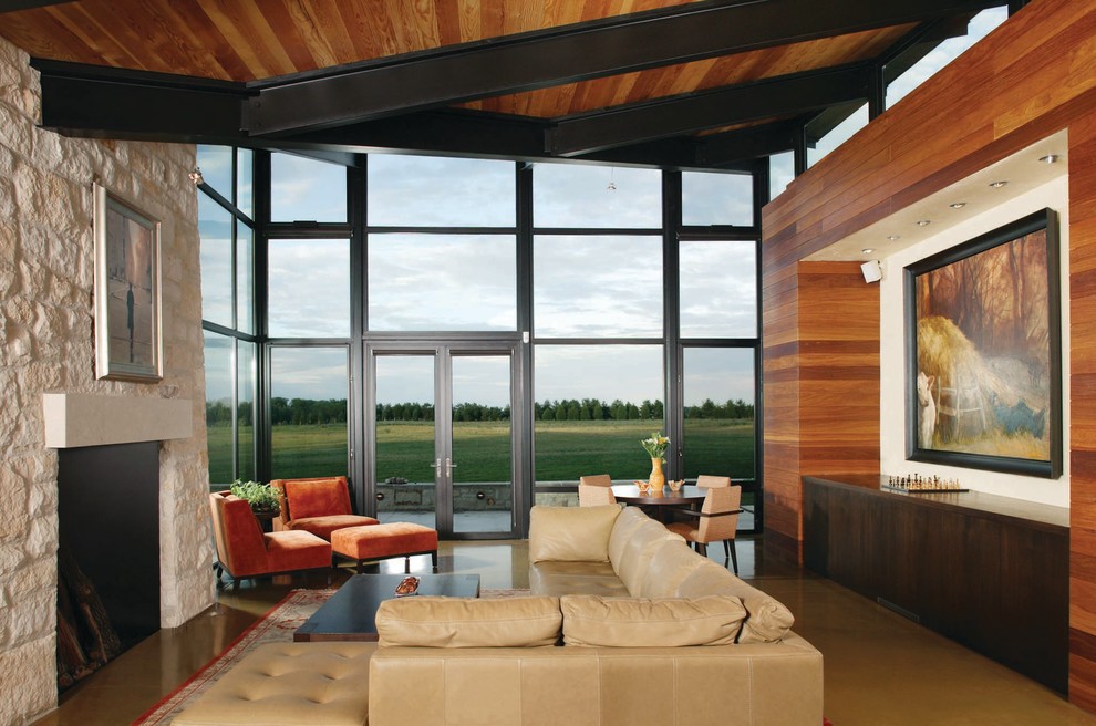 Идея дизайна: открытая гостиная комната в современном стиле с бетонным полом, стандартным камином и фасадом камина из камня без телевизора