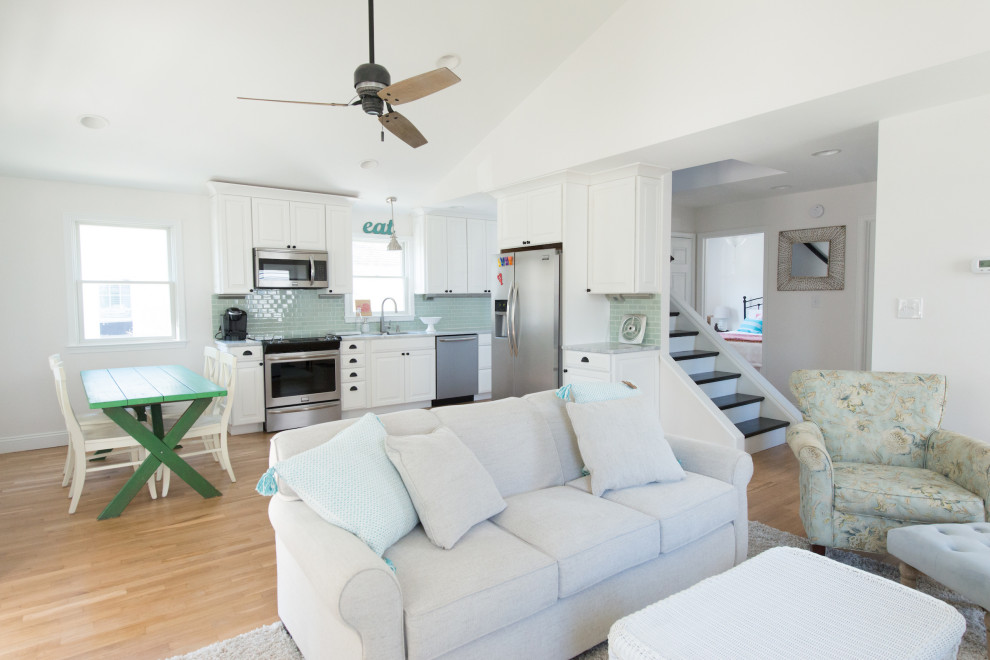 Example of a mid-sized beach style open concept medium tone wood floor family room design in Other with white walls