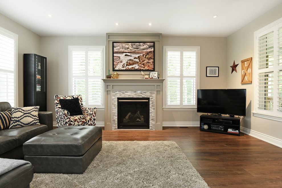 Mittelgroßes, Offenes Rustikales Wohnzimmer mit grauer Wandfarbe, Laminat, Kamin, Kaminumrandung aus Holz und braunem Boden in Ottawa