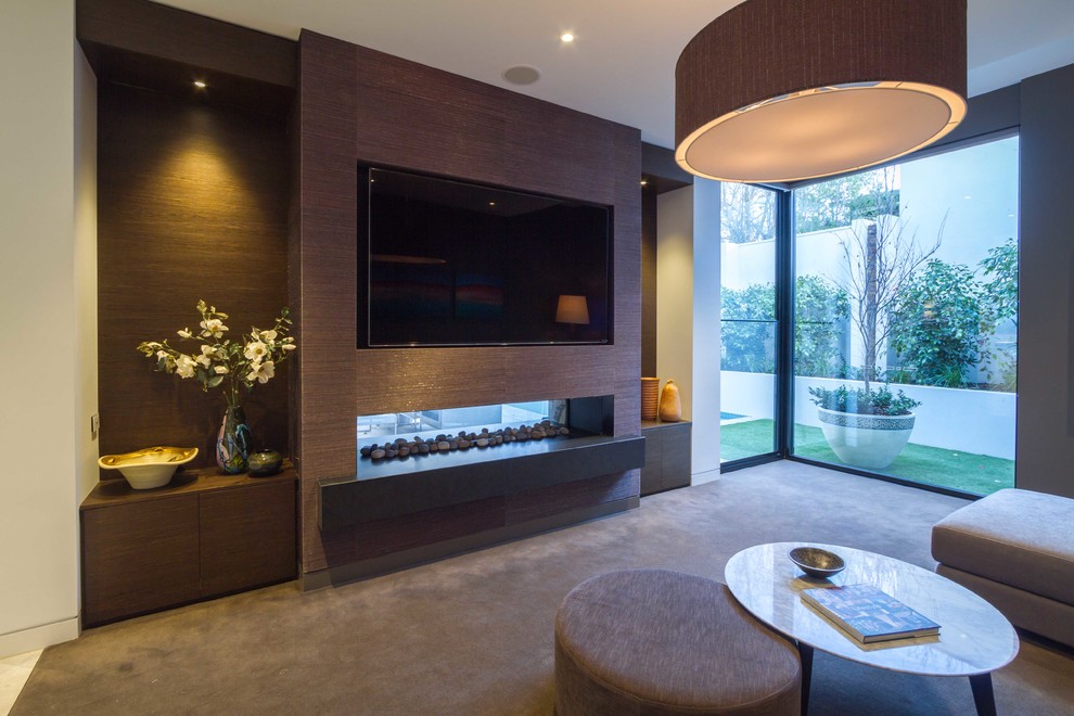 Cette image montre une grande salle de séjour design ouverte avec moquette, une cheminée double-face et un téléviseur encastré.