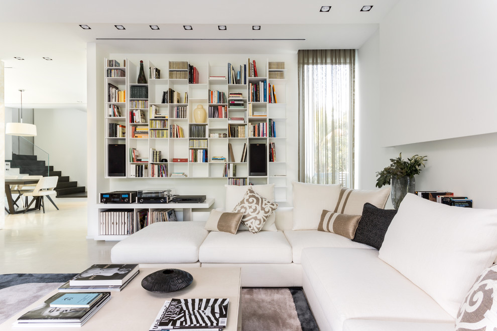 Immagine di un soggiorno contemporaneo aperto con libreria, pareti bianche e pavimento bianco