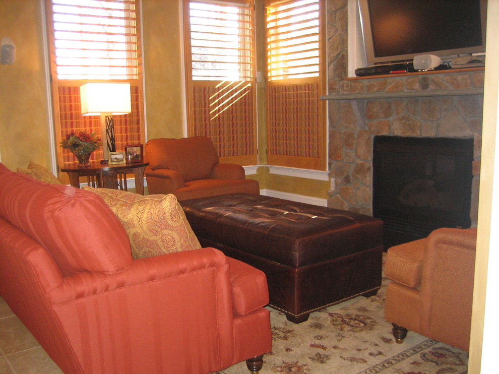 Exempel på ett mellanstort klassiskt avskilt allrum, med bruna väggar, heltäckningsmatta, en standard öppen spis, en spiselkrans i sten, en fristående TV och beiget golv