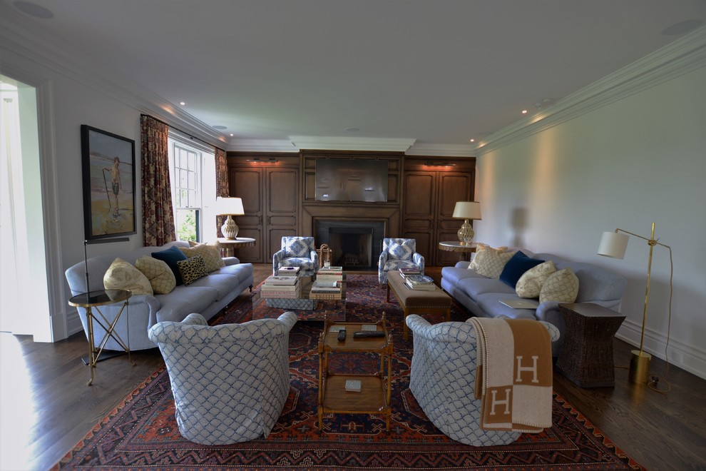 Cette image montre une grande salle de séjour traditionnelle ouverte avec un mur blanc, parquet foncé, un poêle à bois, un manteau de cheminée en carrelage, un téléviseur fixé au mur et un sol marron.