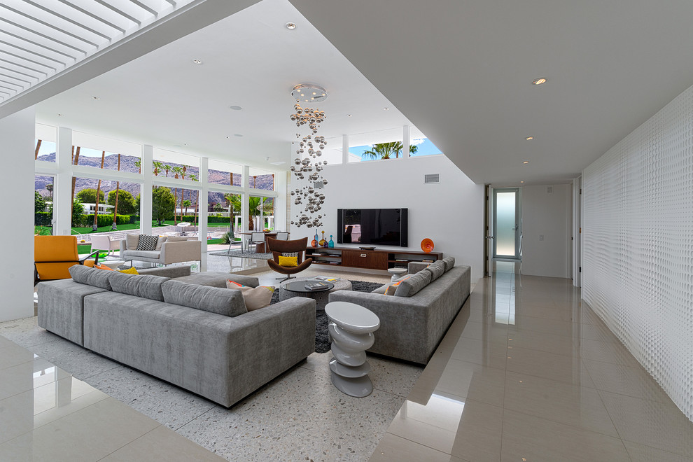 Foto di un soggiorno moderno aperto con pareti bianche, pavimento in travertino e TV a parete