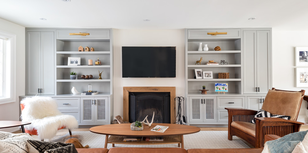 Farmhouse open concept light wood floor family room library photo in Toronto with white walls, a standard fireplace, a wood fireplace surround and a wall-mounted tv