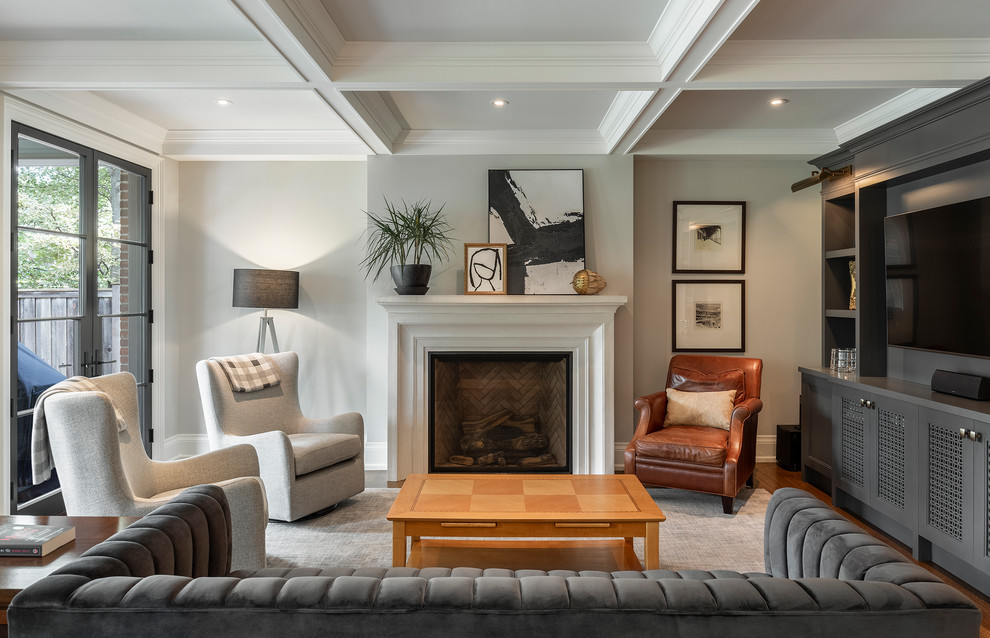 Inspiration for a timeless medium tone wood floor and brown floor family room remodel in Toronto with gray walls, a standard fireplace and a wall-mounted tv