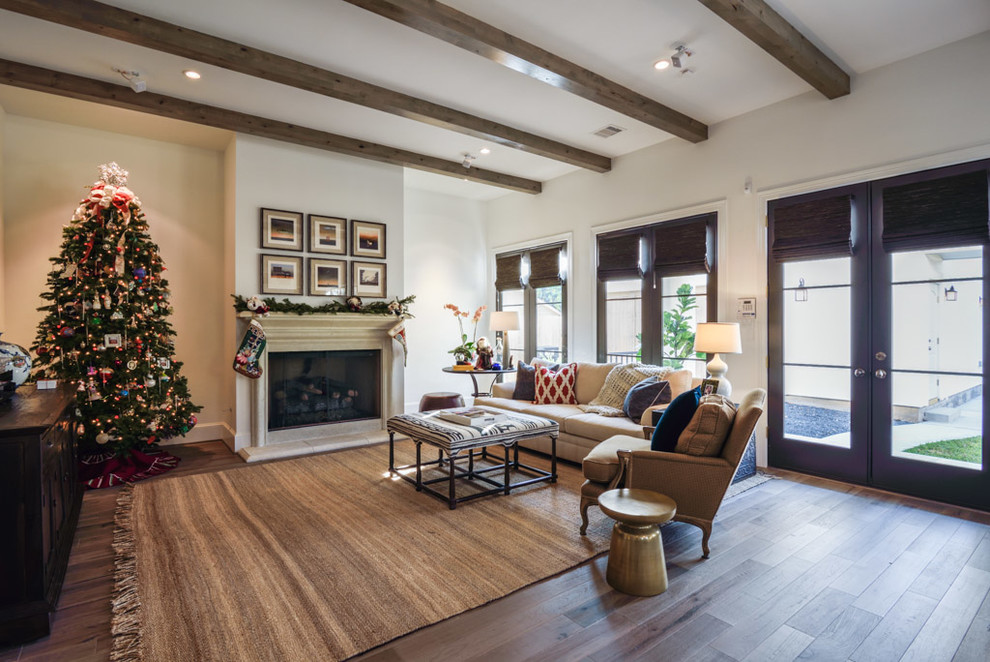 Modelo de sala de estar abierta tradicional renovada grande con paredes blancas, suelo de madera clara, todas las chimeneas y marco de chimenea de yeso
