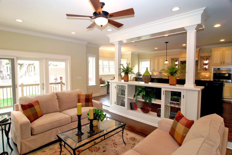 Modelo de sala de estar abierta tradicional con paredes beige, suelo de madera oscura y alfombra