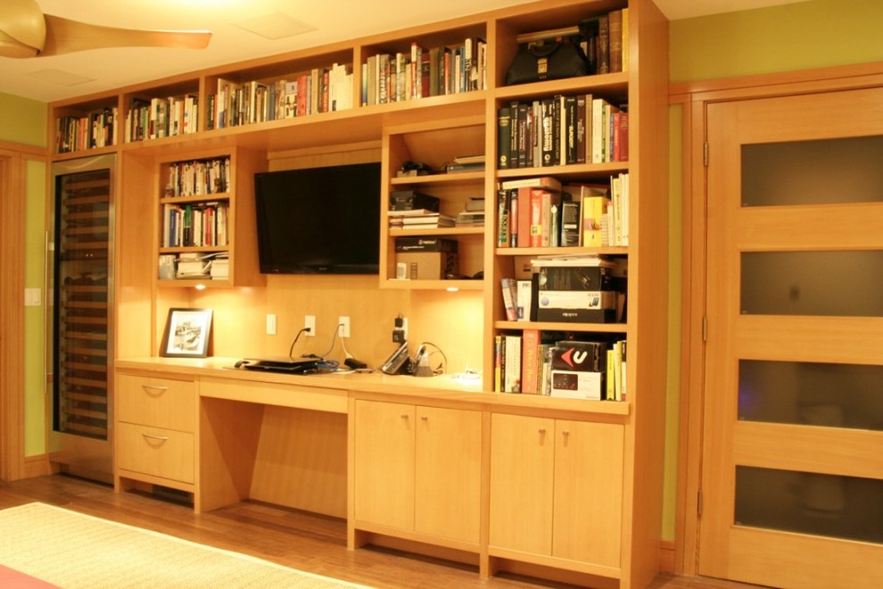 Idee per un soggiorno design di medie dimensioni e chiuso con libreria, pareti verdi, parquet chiaro e parete attrezzata